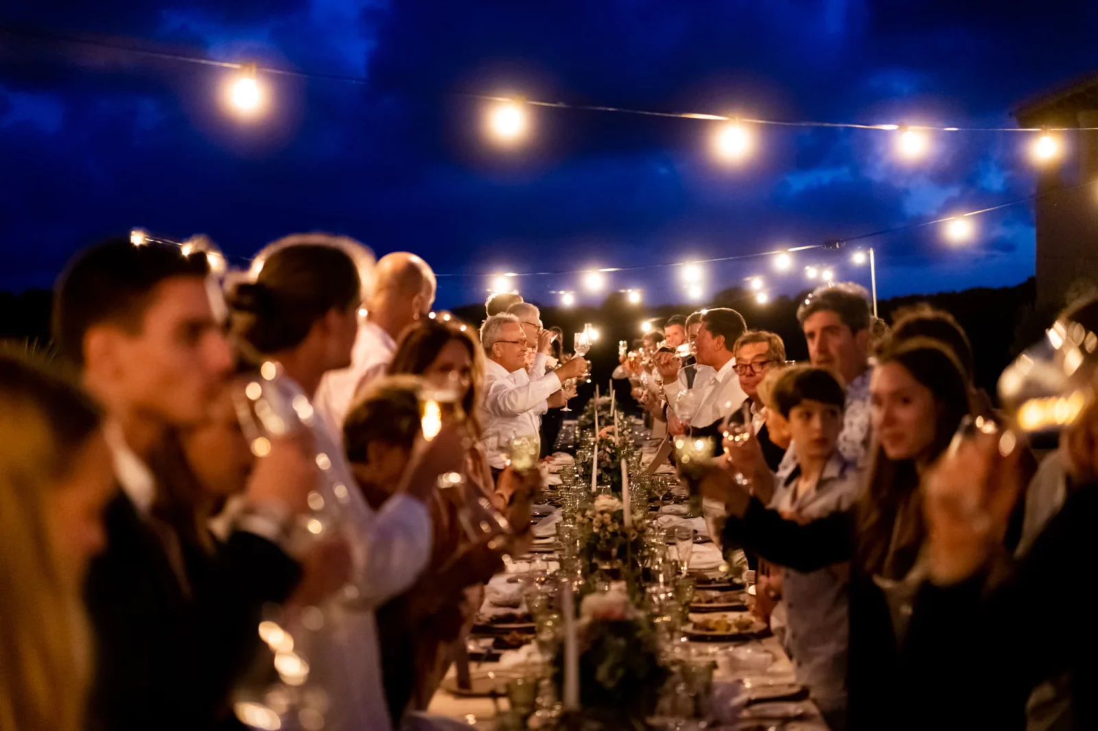 Hochzeitstafel in der blauen Stunde unter Lichterketten